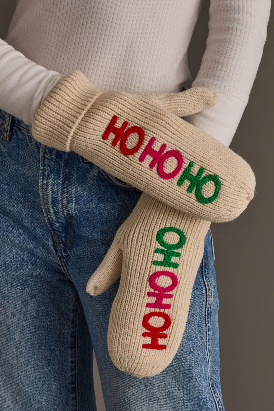 Beige Ho Ho Ho Mittens featuring embroidered text in alternating red, pink, and green letters.