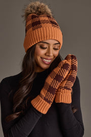 A woman wearing the Panache Apparel Collection Orange & Brown Plaid Knit Pom Hat, smiling with her eyes closed, pairs it with matching mittens and a black top.