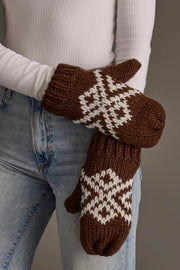 A person wearing blue jeans, a white ribbed top, and the Panache Apparel Collection Brown & White Patterned Mittens stands against a plain background.