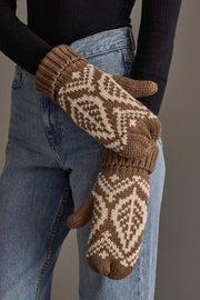 A person wearing blue jeans, a black long-sleeve top, and Panache Apparel Collection Taupe & Beige Patterned Knit Mittens stands against a plain background.