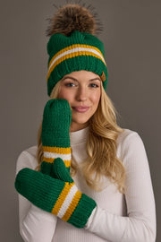 A smiling woman in a white turtleneck wears the Panache Apparel Collection Green, Gold & White Knit Pom Hat, posing against a plain background.