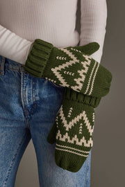 A person wearing Panache Apparel Collection’s Olive & Beige Patterned Mittens, a white ribbed long-sleeve shirt, and blue jeans, with their arms crossed in front of their body.