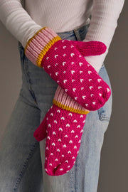 A person wearing light blue jeans, a white ribbed long-sleeve shirt, and Panache Apparel Collection Pink, White & Light Pink Heart Design Mittens.