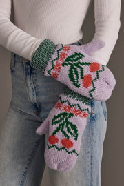 A person wearing Panache Apparel Collection’s Light Purple Cherry Pattern Mittens, styled with blue jeans and a white ribbed long-sleeve shirt.