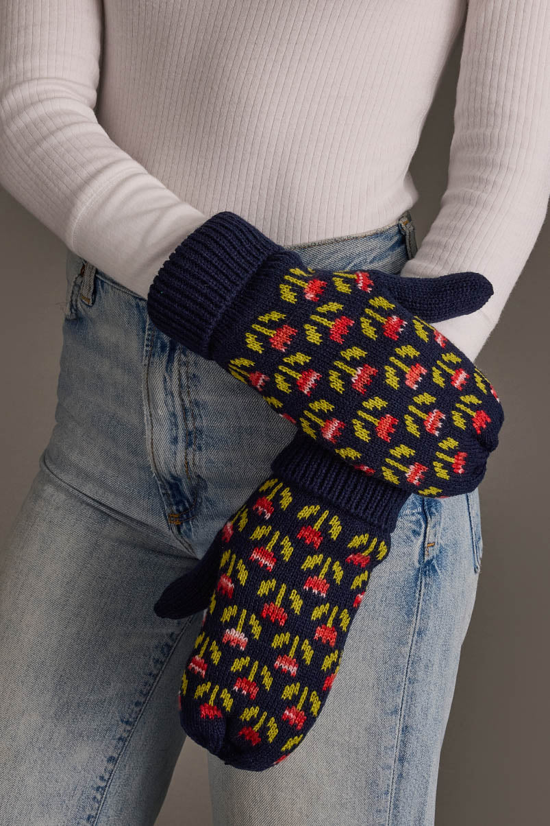 A person in a white ribbed top and light blue jeans is wearing the Panache Apparel Collection’s Navy Small Floral Pattern Knit Mittens, standing against a neutral background.