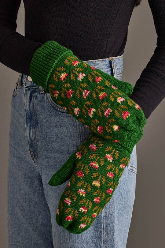 A person wearing blue jeans and a black ribbed shirt showcases the Panache Apparel Collection’s Green Small Floral Pattern Knit Mittens.