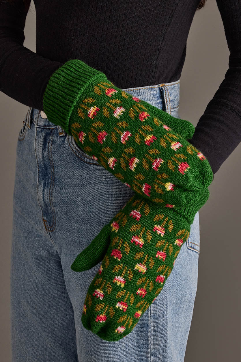 A person wearing blue jeans and a black ribbed shirt showcases the Panache Apparel Collection’s Green Small Floral Pattern Knit Mittens.