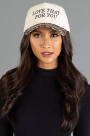 A woman wearing a Love That For You Ivory & Leopard Two-Toned Trucker Hat with ivory fabric, the text LOVE THAT FOR YOU, and a leopard print brim.