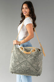 A woman smiles in a white tee and light jeans, carrying the Panache Apparel Collection Gray Vintage Inspired Textured Tote with tan suede handles and zipper closure against a plain gray background.