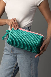 A person wearing a white top and jeans holds the Panache Apparel Collection Green & Pink Ribbed Travel Pouch.