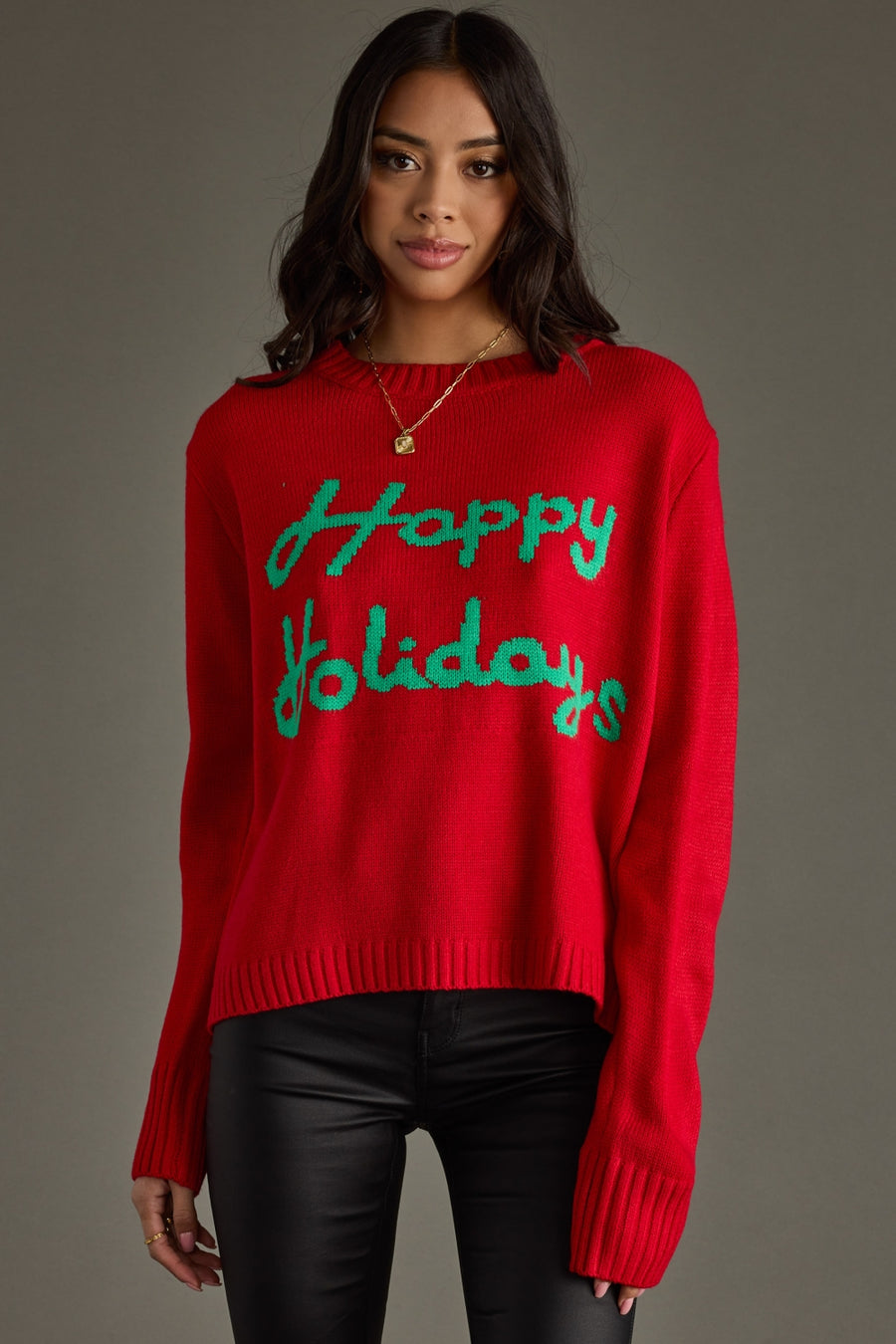 Person wearing a red sweater with 'Happy Holidays' text on a gray background