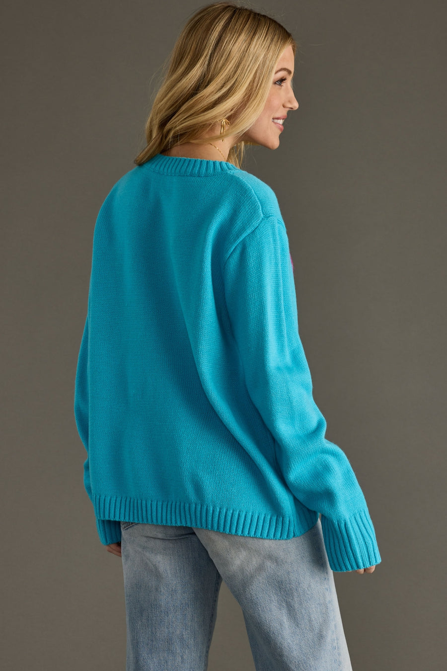 Woman wearing a bright blue sweater against a gray background