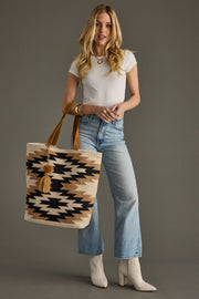Woman holding a patterned tote bag against a gray background