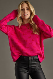 Woman wearing a bright pink sweater with text pattern against a gray background