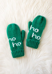 Pair of green mittens with 'ho ho' text on a white fur background