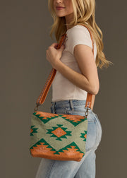 Woman holding a patterned handbag against a plain background