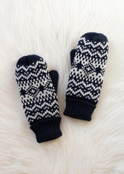 Pair of dark navy and white patterned mittens on a textured white surface