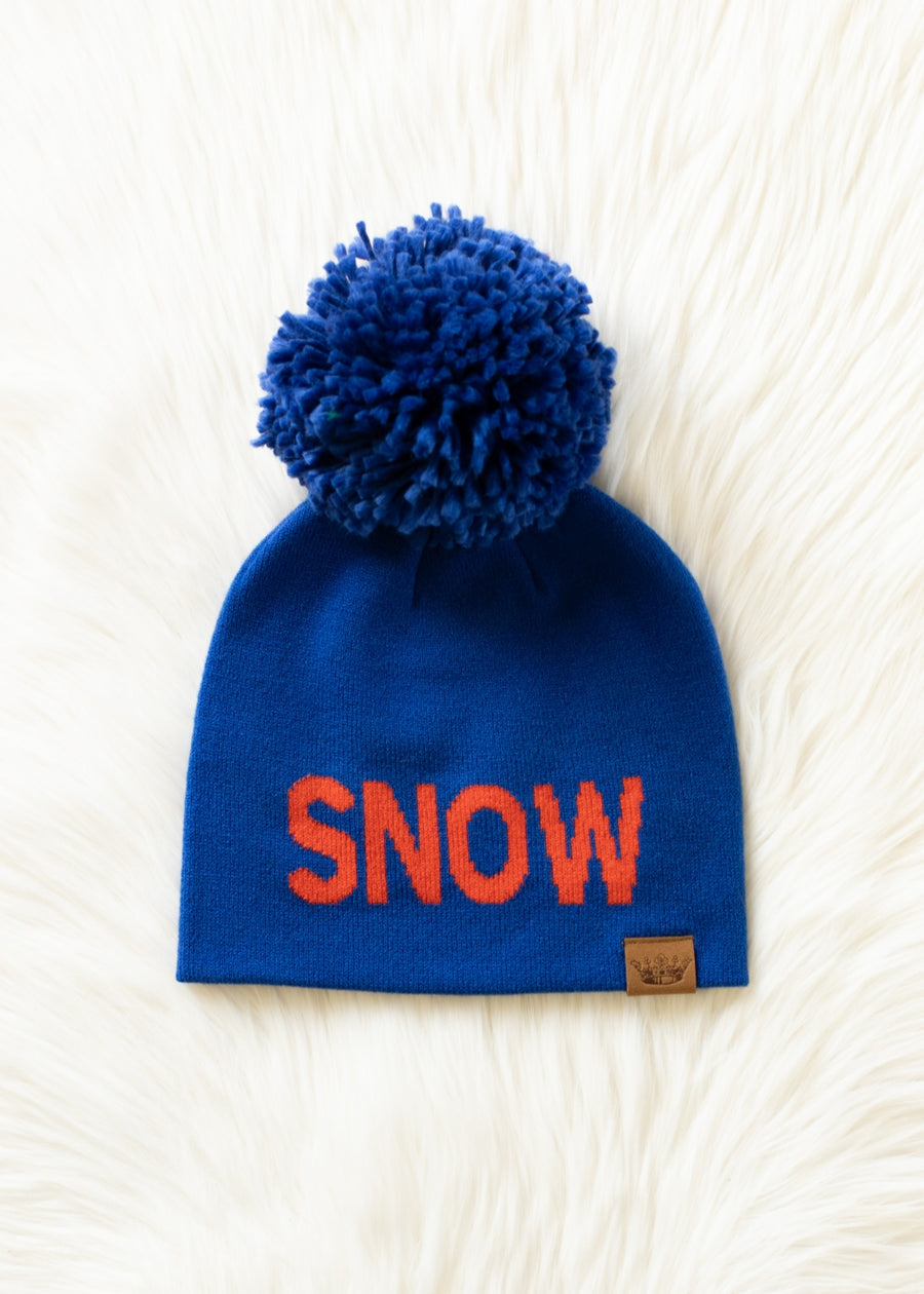 Blue beanie with red 'SNOW' text and blue pom-pom on a white textured background