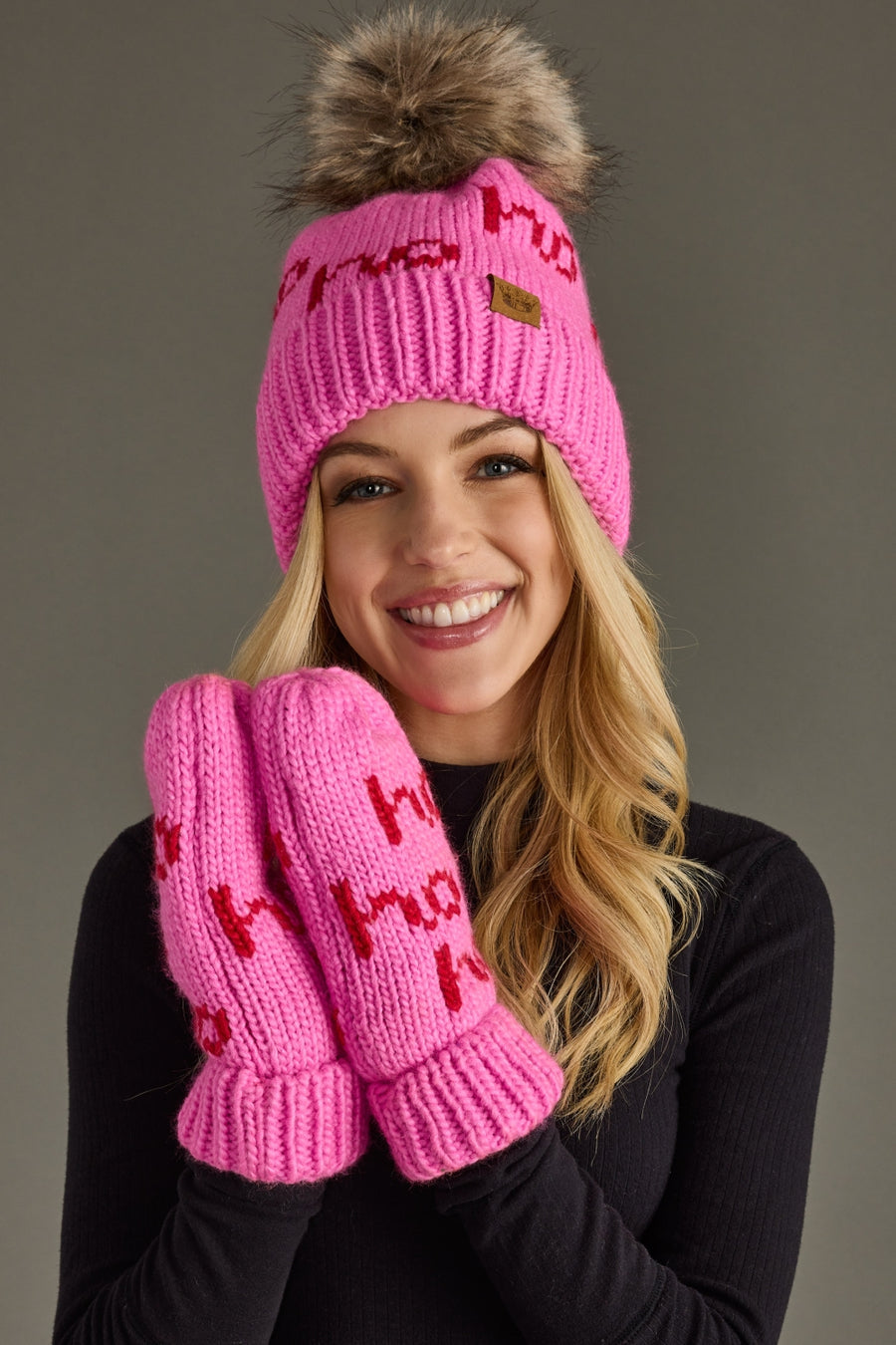 Woman wearing a pink knit hat and mittens with text on a gray background