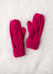 Pair of pink knitted mittens on a white textured surface
