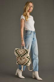 Woman holding a patterned bag against a gray background