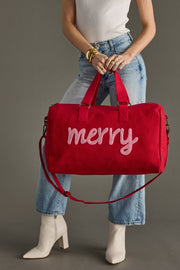 Person holding a red bag with 'merry' text against a gray background