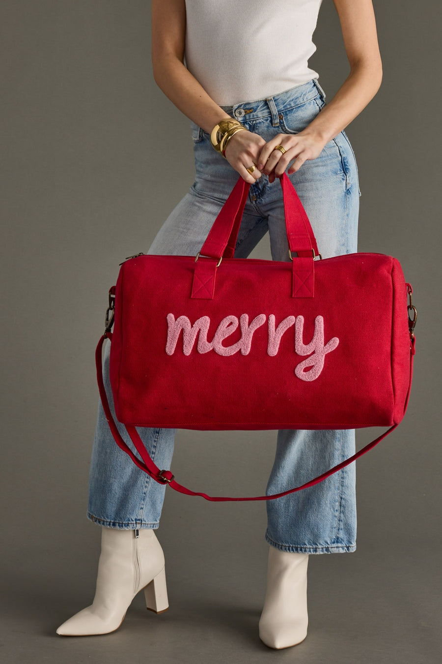 Person holding a red bag with 'merry' text against a gray background