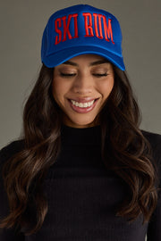 Woman wearing a blue cap with red text on a gray background