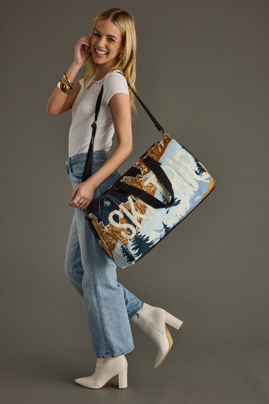 Woman holding a decorative bag against a gray background