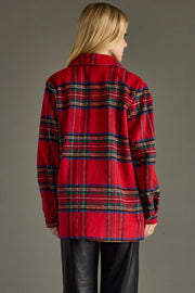 Person wearing a red plaid shirt against a gray background
