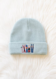 Light blue beanie with embroidered designs on a white background