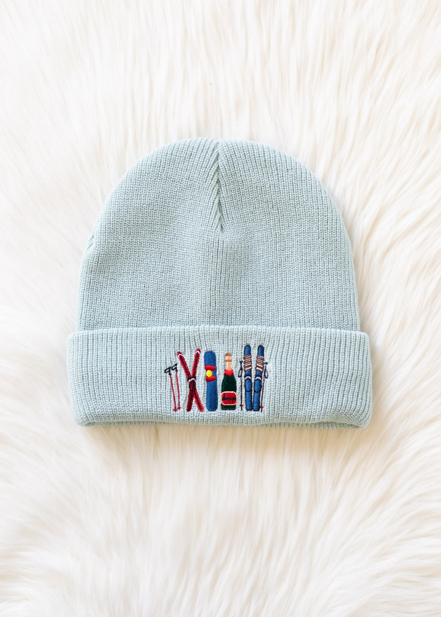Light blue beanie with embroidered designs on a white background