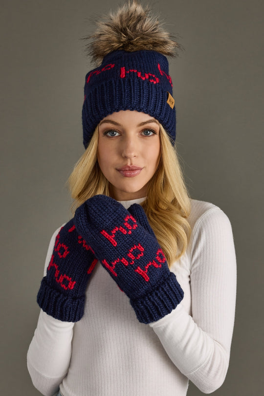 Person wearing a navy blue knit hat and mittens with red text on a gray background