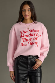 Person wearing a pink sweatshirt with red text on a gray background
