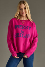 Woman wearing a pink sweater with 'Merry & Bright' text on a gray background