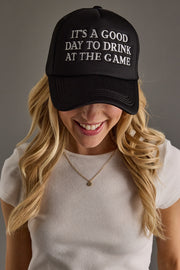 Person wearing a black cap with text and a plain background