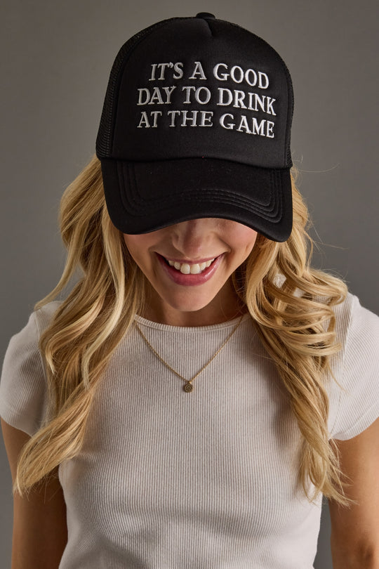 Person wearing a black cap with text and a plain background
