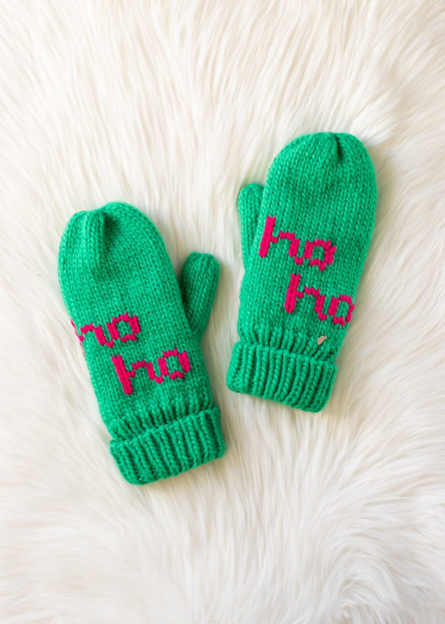 Green mittens with 'ho ho' text on a white fur background