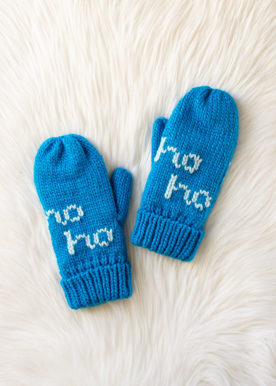 Pair of blue knitted mittens with 'Ho Ho' text on a white fur background